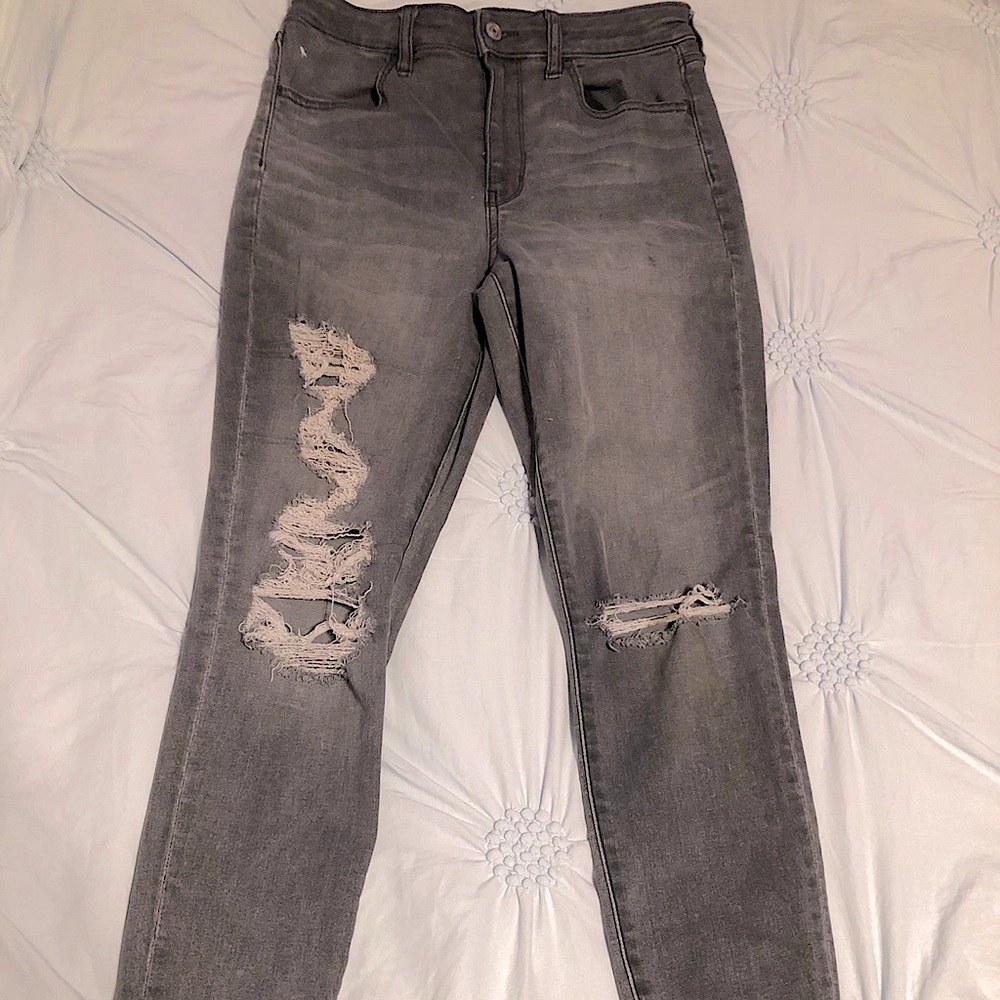Stretchy gray skinny jeans distressed with rips.